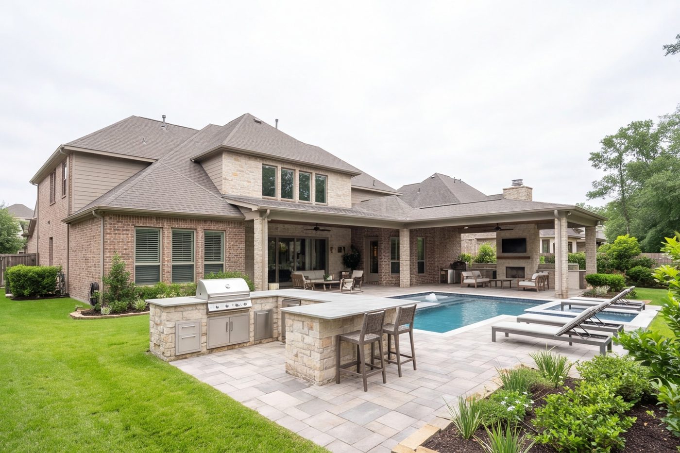 wide back yard with stone patio, pool deck and planting, house in frame